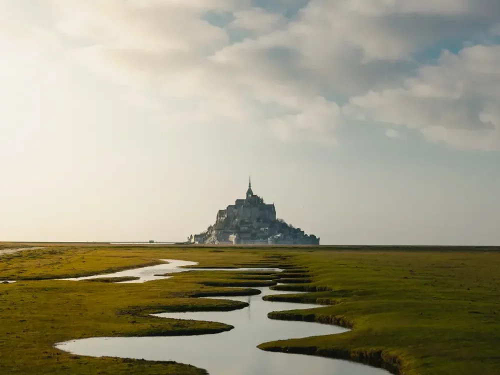 stunning view of the mont saint michel in france, far in the background with the bay at low tide on the foreground